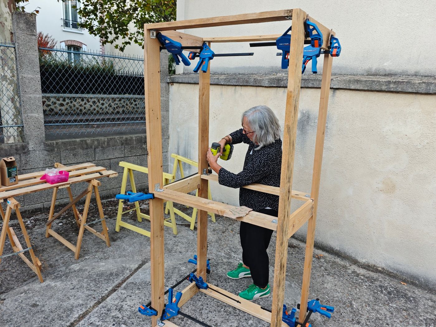 Bénévole assemblant une structure en bois de palette